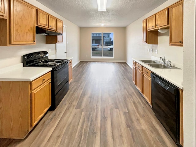 kitchen featuring hardwood / wood-style flooring, sink, a textured ceiling, and black appliances