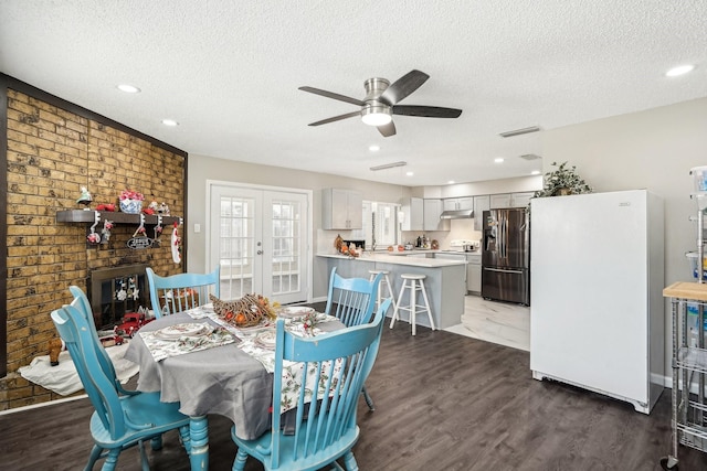 dining space featuring french doors, ceiling fan, dark hardwood / wood-style flooring, and a textured ceiling