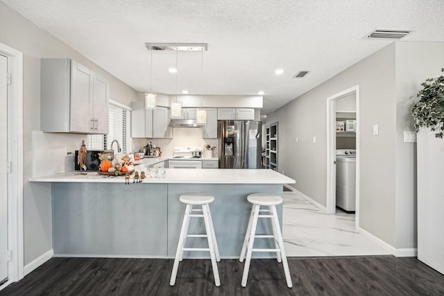 kitchen featuring hanging light fixtures, gray cabinetry, kitchen peninsula, and stainless steel fridge with ice dispenser