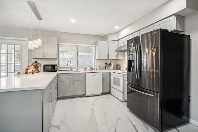 kitchen with pendant lighting, sink, white appliances, gray cabinets, and a healthy amount of sunlight