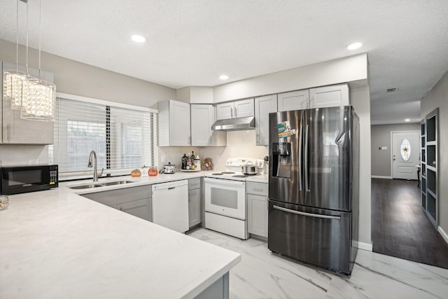 kitchen with sink, hanging light fixtures, a textured ceiling, gray cabinets, and white appliances