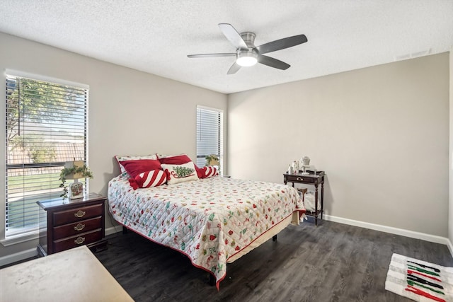 bedroom featuring dark hardwood / wood-style flooring, ceiling fan, and a textured ceiling