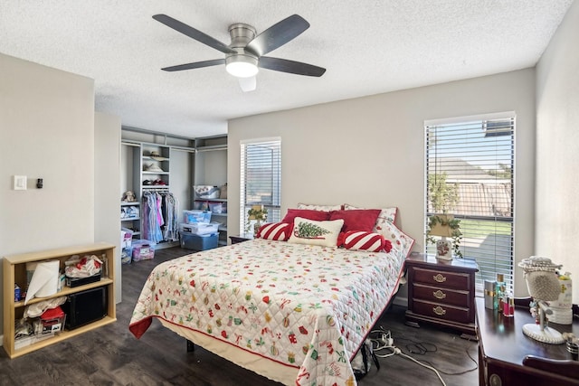 bedroom featuring ceiling fan, dark hardwood / wood-style flooring, a closet, and a textured ceiling