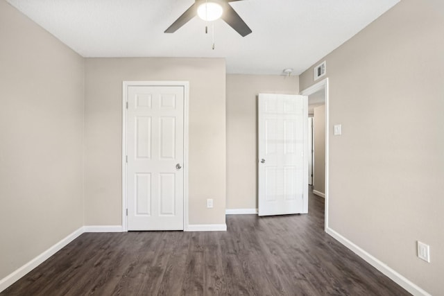 unfurnished bedroom featuring dark wood-type flooring and ceiling fan