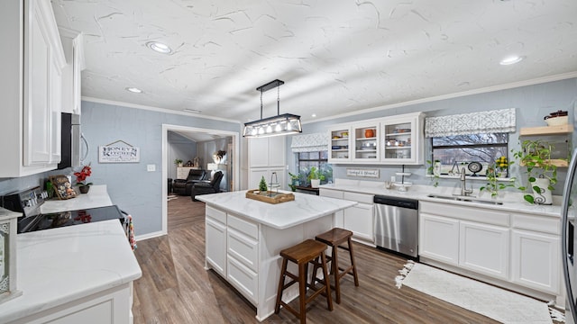 kitchen featuring sink, hanging light fixtures, stainless steel appliances, white cabinets, and a kitchen island