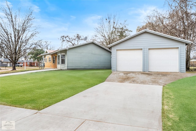 ranch-style home featuring an outbuilding, a garage, and a front lawn