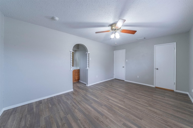 spare room with ceiling fan, dark hardwood / wood-style floors, and a textured ceiling