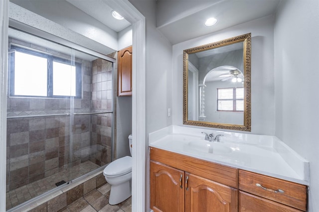 bathroom with vanity, a wealth of natural light, walk in shower, and toilet