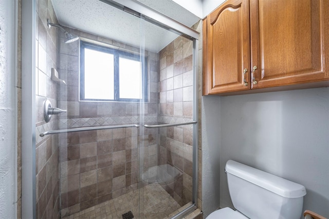 bathroom with a shower with door and toilet