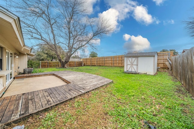 view of yard featuring a wooden deck and a storage unit