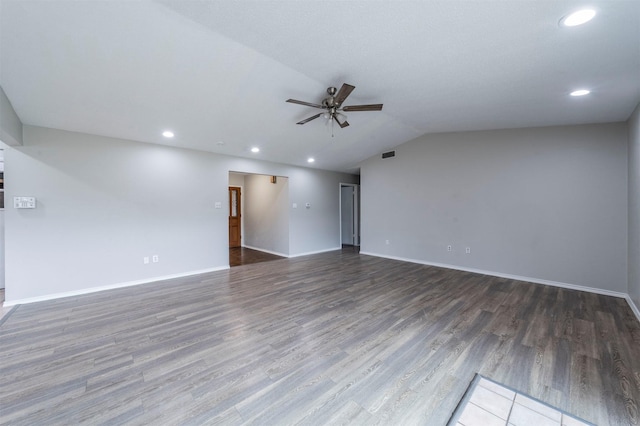 empty room with lofted ceiling, dark hardwood / wood-style floors, and ceiling fan