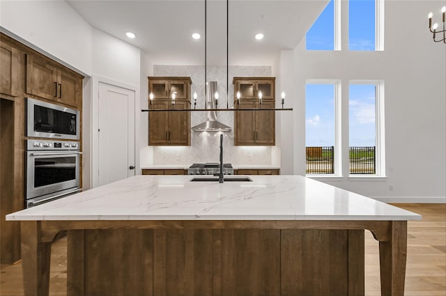 kitchen featuring a large island, built in microwave, oven, and hanging light fixtures