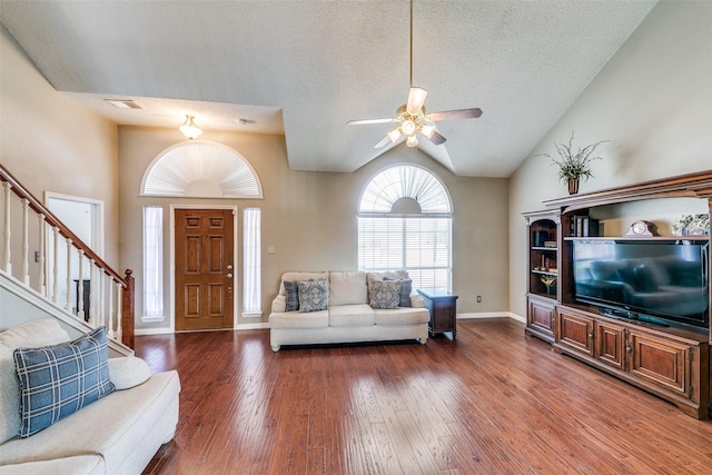 living room with lofted ceiling, wood-type flooring, visible vents, stairway, and a textured ceiling