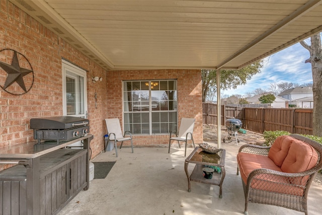 view of patio featuring a grill and fence