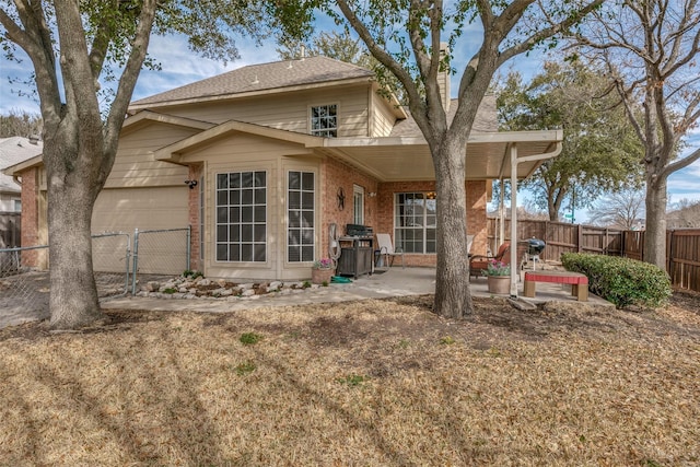 back of property with a patio, roof with shingles, an attached garage, fence, and brick siding