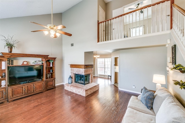 living area featuring baseboards, visible vents, a ceiling fan, wood finished floors, and a fireplace