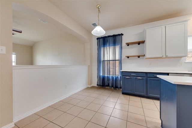 kitchen with blue cabinetry, tasteful backsplash, hanging light fixtures, light tile patterned floors, and white cabinets