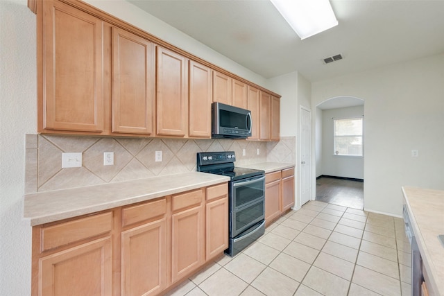 kitchen featuring tasteful backsplash, appliances with stainless steel finishes, light tile patterned floors, and light brown cabinetry