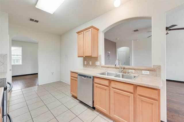 kitchen with appliances with stainless steel finishes, sink, decorative backsplash, ceiling fan, and light brown cabinets