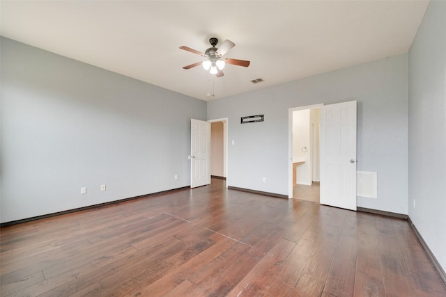 unfurnished bedroom with ensuite bathroom, dark wood-type flooring, and ceiling fan