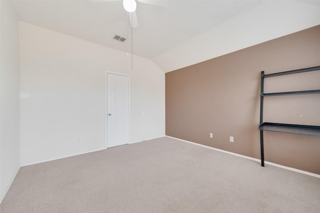 carpeted spare room with ceiling fan and vaulted ceiling