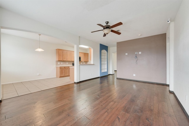 unfurnished living room with ceiling fan and light hardwood / wood-style floors