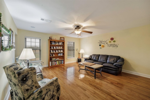 living room with light hardwood / wood-style flooring and ceiling fan