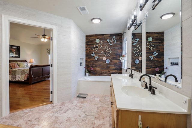 bathroom featuring vanity, a tub to relax in, and ceiling fan