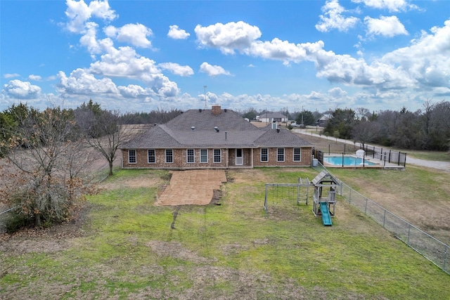 exterior space with a fenced in pool, a playground, a patio area, and a lawn