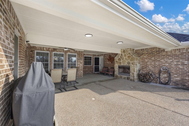 view of patio / terrace featuring area for grilling and an outdoor stone fireplace