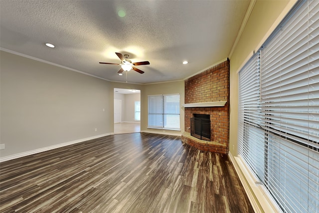 unfurnished living room featuring a fireplace, ornamental molding, dark hardwood / wood-style floors, and a textured ceiling