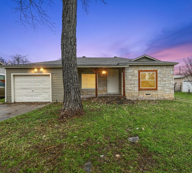 ranch-style home with a yard and a garage