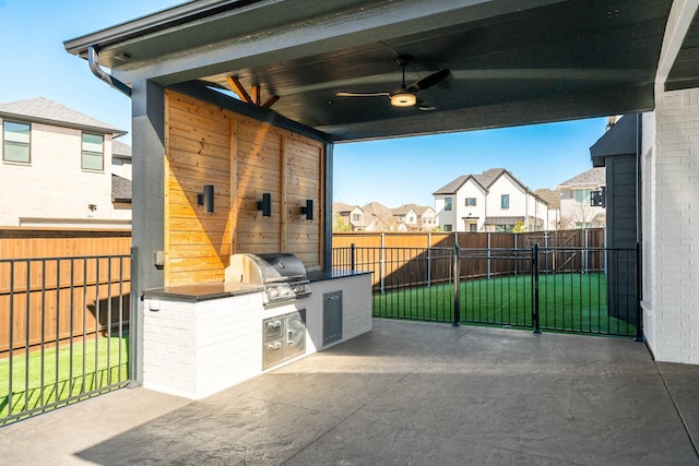 view of patio with area for grilling, a ceiling fan, exterior kitchen, a residential view, and a fenced backyard