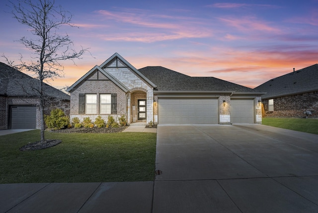 view of front of property with a garage and a yard