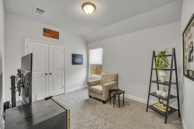 living area with carpet floors, visible vents, vaulted ceiling, and baseboards