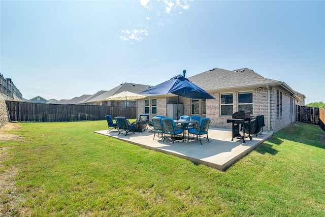 back of house with a patio, a fenced backyard, brick siding, a shingled roof, and a yard