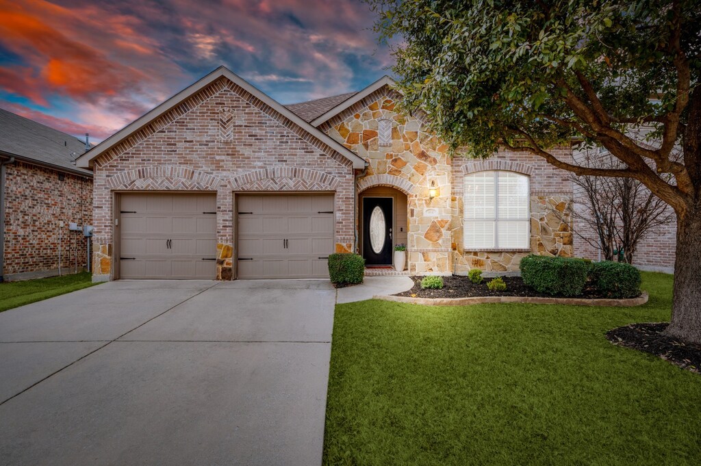 604 Hummingbird Dr, Little Elm, TX 75068 - french provincial home featuring an attached garage, a front yard, driveway, and brick siding