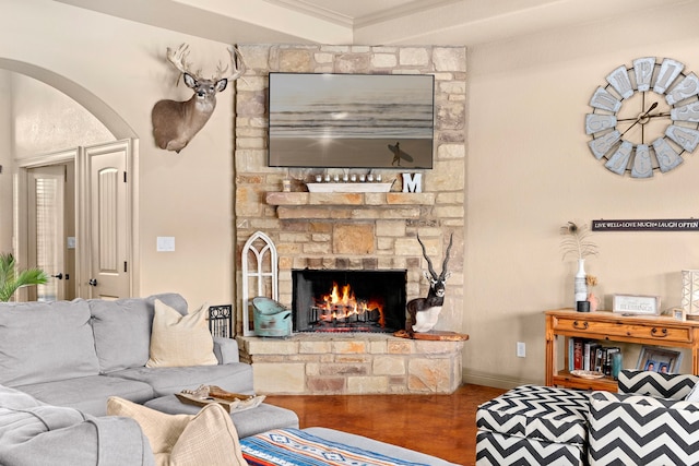 living room with hardwood / wood-style floors, crown molding, and a fireplace