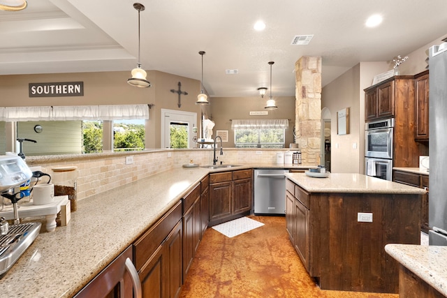 kitchen featuring sink, pendant lighting, stainless steel appliances, light stone countertops, and decorative backsplash