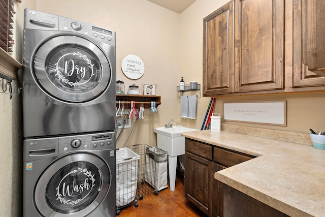 clothes washing area with cabinets and stacked washer and clothes dryer