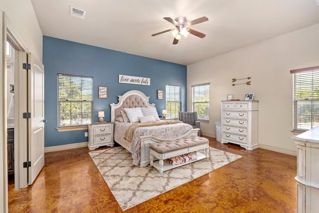 bedroom featuring ceiling fan, concrete flooring, and multiple windows