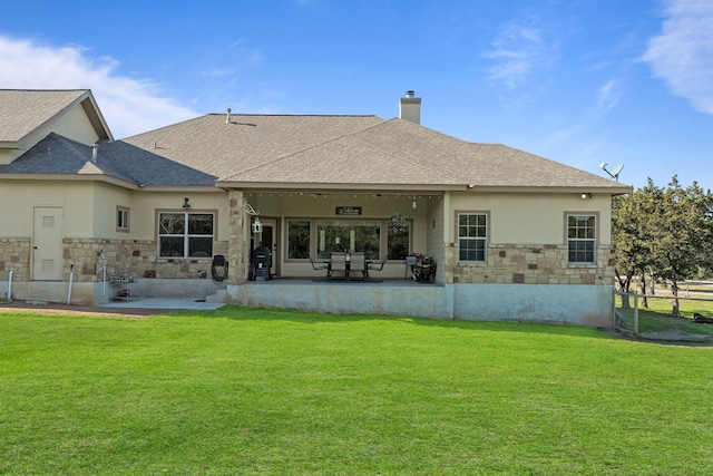 rear view of property featuring a patio area and a lawn