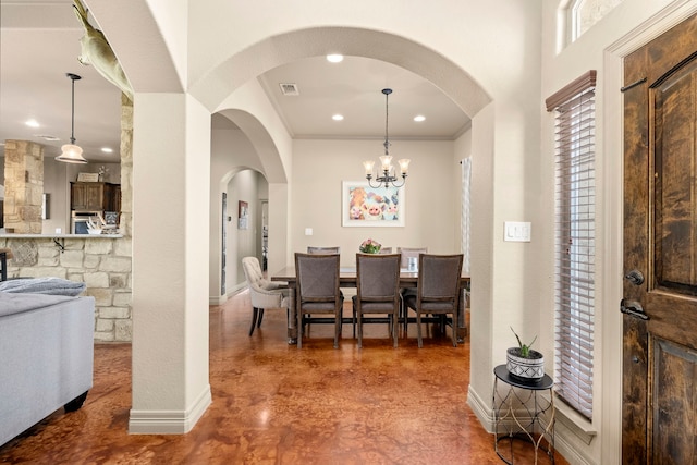 dining space featuring crown molding, concrete floors, and a chandelier