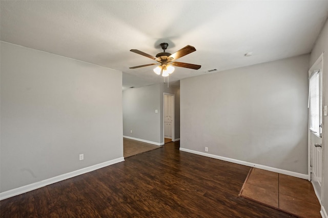 spare room with dark hardwood / wood-style floors and ceiling fan