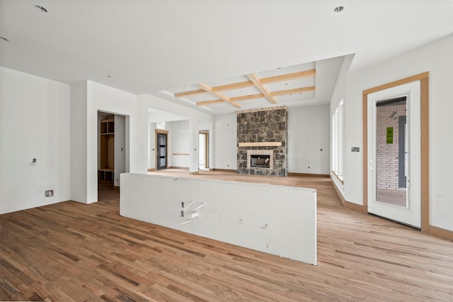 kitchen featuring coffered ceiling, hardwood / wood-style flooring, a fireplace, and beamed ceiling