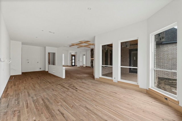 unfurnished living room with a brick fireplace and light hardwood / wood-style flooring