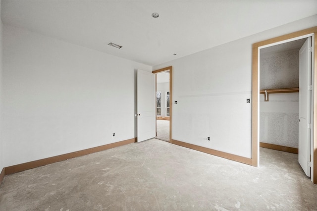 unfurnished bedroom featuring concrete flooring and a closet