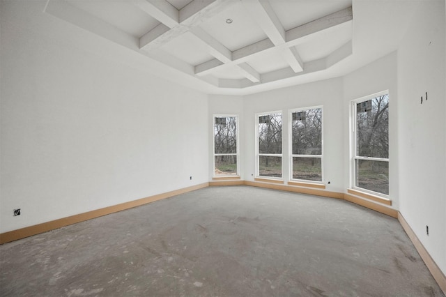 spare room with concrete flooring, a high ceiling, coffered ceiling, and beam ceiling