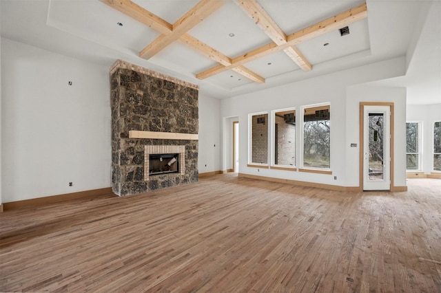 unfurnished living room with a fireplace, wood-type flooring, coffered ceiling, and beam ceiling