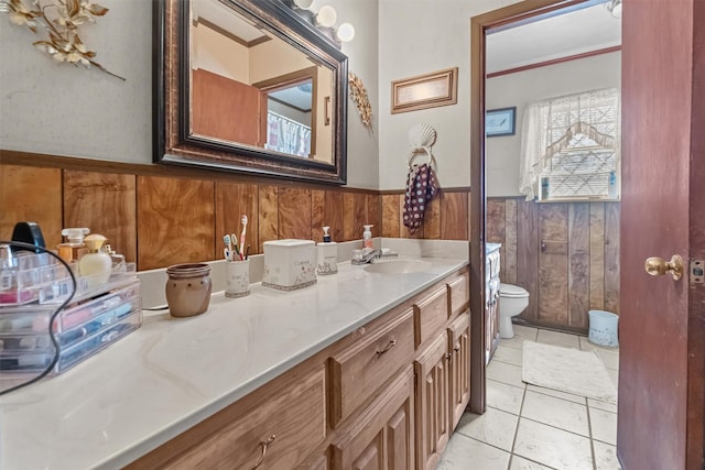 bathroom featuring vanity, tile patterned floors, toilet, and wood walls